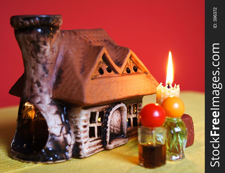 Composition with aromatic house. There is a candle inside the house which is heating the aromatic oil up. Composition with aromatic house. There is a candle inside the house which is heating the aromatic oil up.