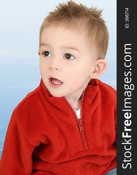 Adorable 1 year old boy in red sweater against blue background. Adorable 1 year old boy in red sweater against blue background.