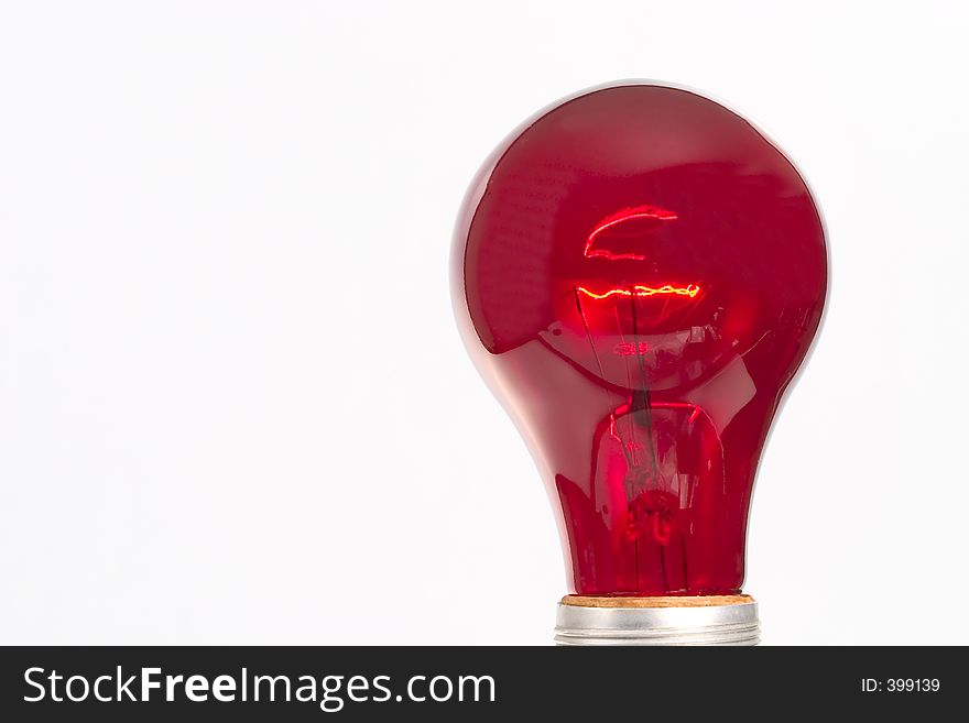 Red light bulb in front of a white background. Red light bulb in front of a white background