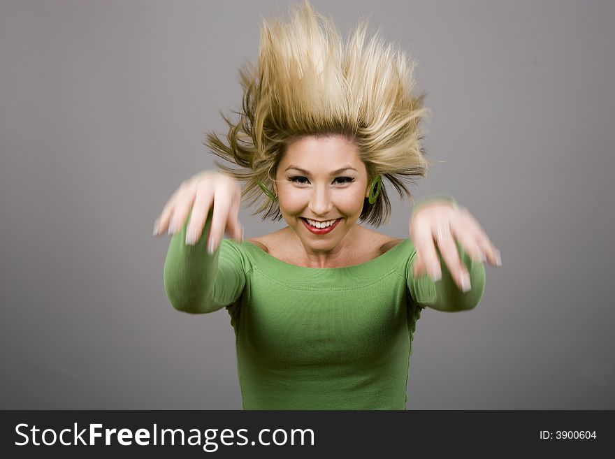 A blonde model in green shirt  jumping with hair flying. A blonde model in green shirt  jumping with hair flying