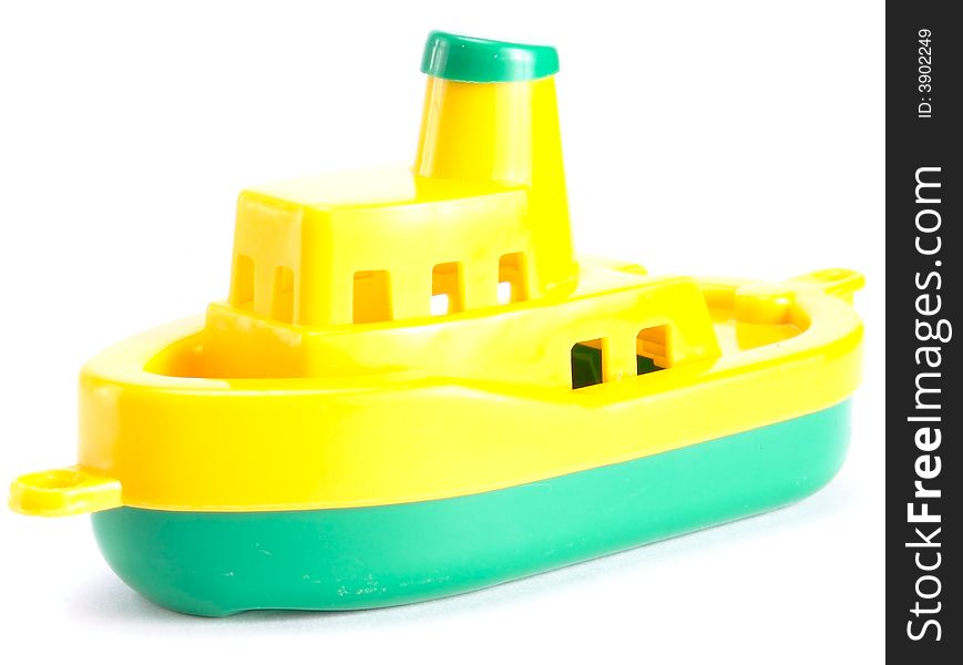 Plastic toy ship. On a white background. Top-yellow. Bottom - 
green.