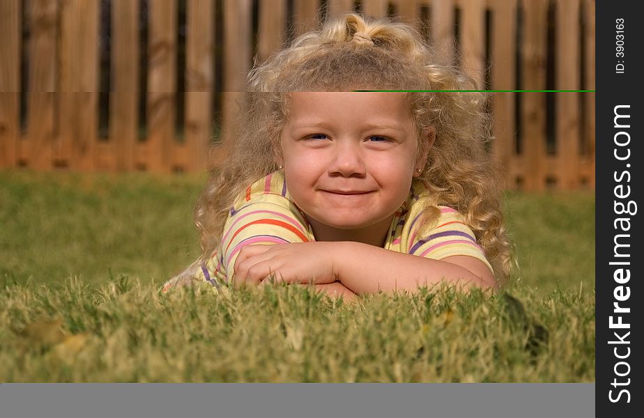 Young girl playing in the grass in the golden light of sunset.  Shallow depth of field.