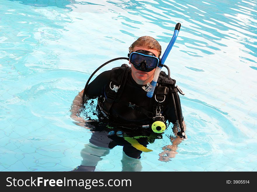 Man in scuba gear in a swimming pool. Man in scuba gear in a swimming pool.