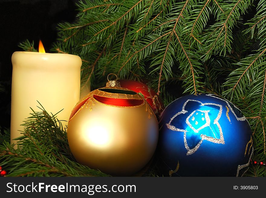 New Year's three spheres and candle on a fur-tree. New Year's three spheres and candle on a fur-tree