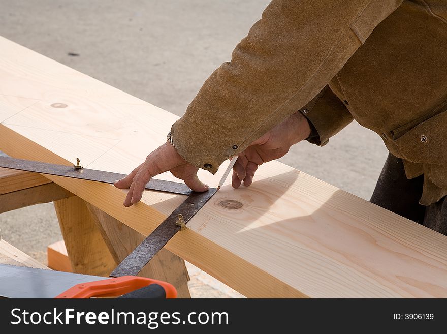 Carpenter laying out a stringer for a staircase to be cut. Carpenter laying out a stringer for a staircase to be cut.