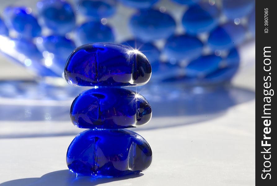 Sunlit beads on white, table, with beads in background. Sunlit beads on white, table, with beads in background