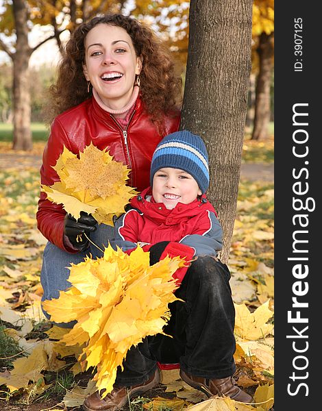 Mother with son in the park in autumn with yellow leaves 2