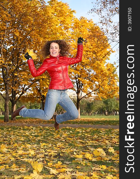 Girl in the red jacket jumps in the park in autumn 2. Girl in the red jacket jumps in the park in autumn 2