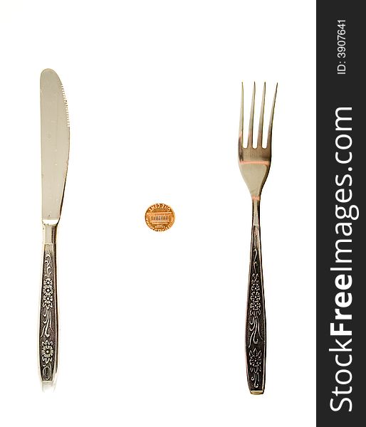 One cent lying between fork and knife. One cent lying between fork and knife