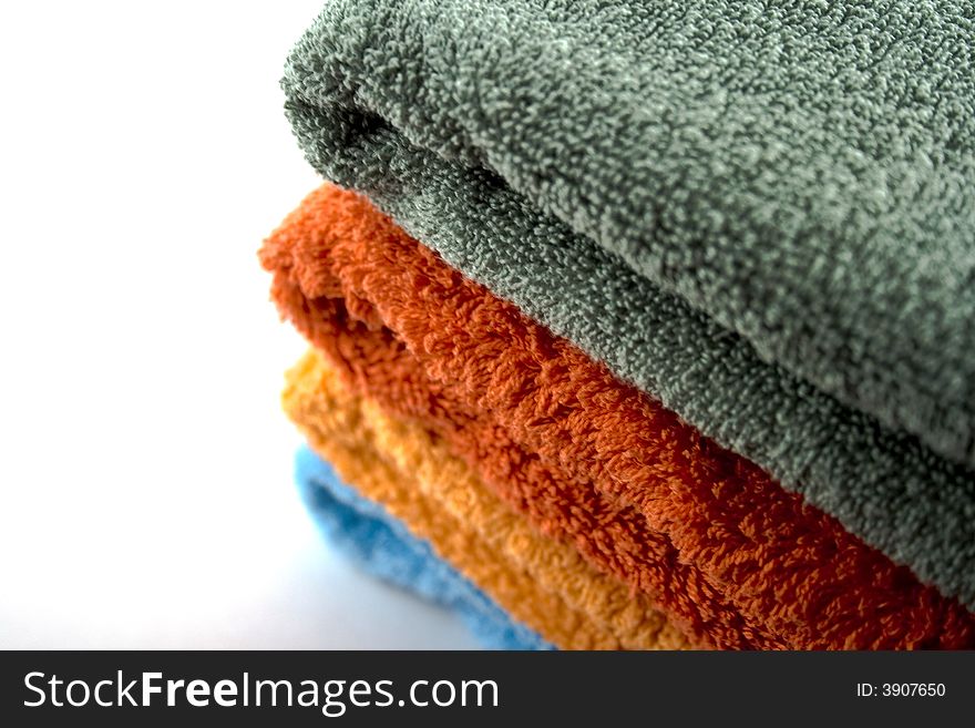 Stack of coloured towels over white