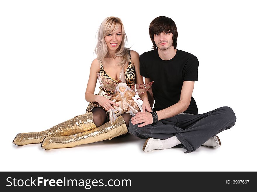 Young couple sit with doll on white