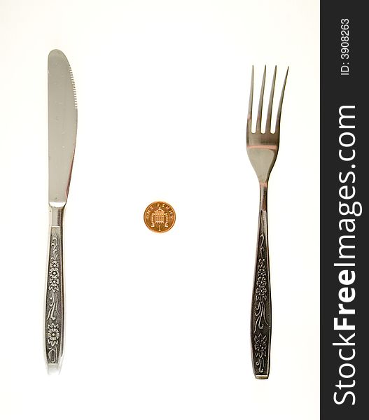 One penny lying between fork and knife. One penny lying between fork and knife