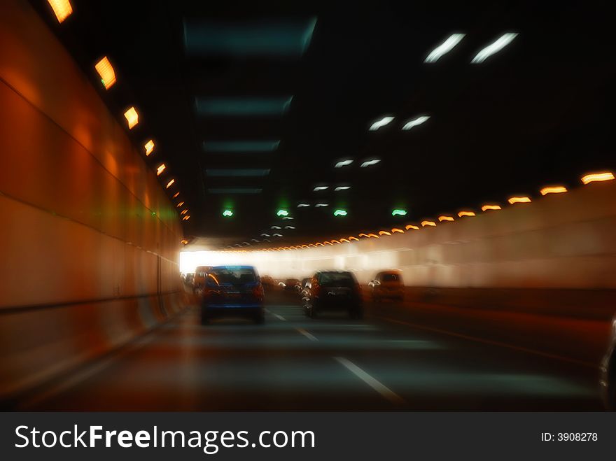 Lights in a dark tunnel ahead with cars