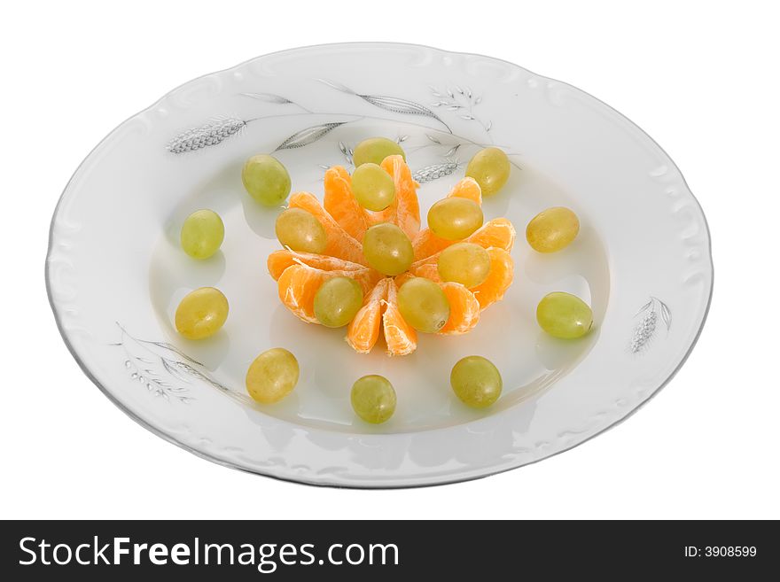 Peeled tangerines and grapes on plate isolated on white