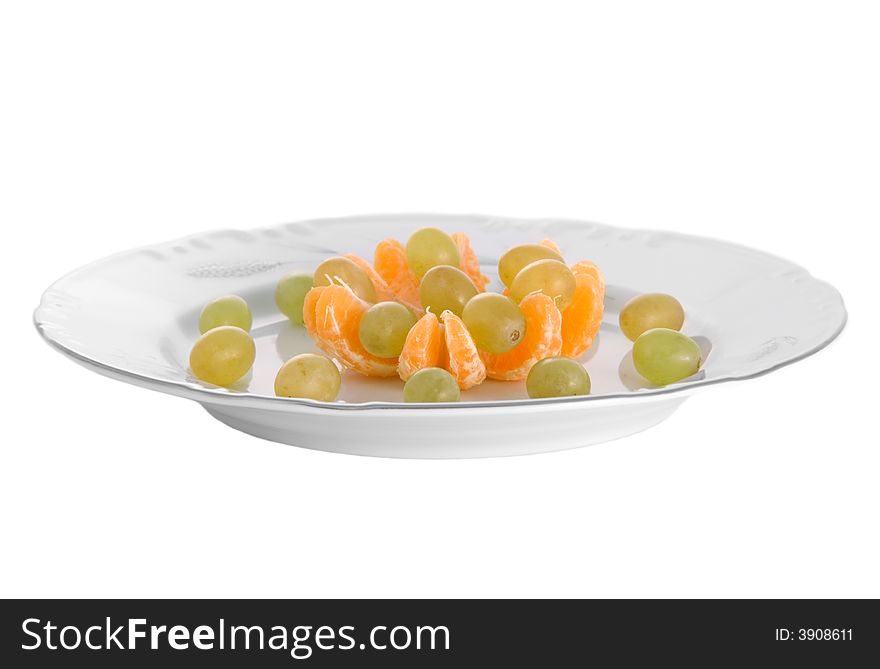 Peeled tangerines and grapes on plate isolated on white