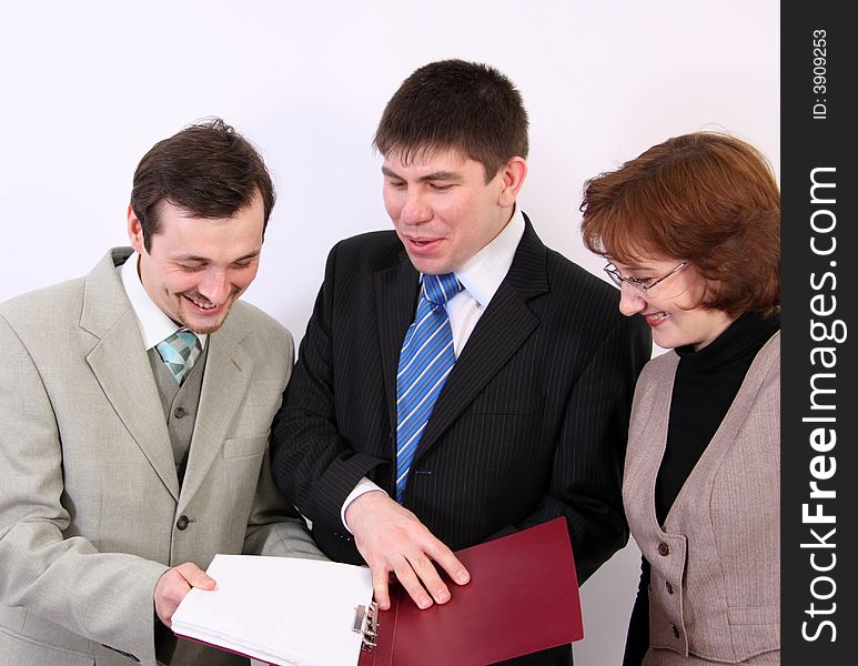 Group of three person consider documents and smile. Group of three person consider documents and smile.