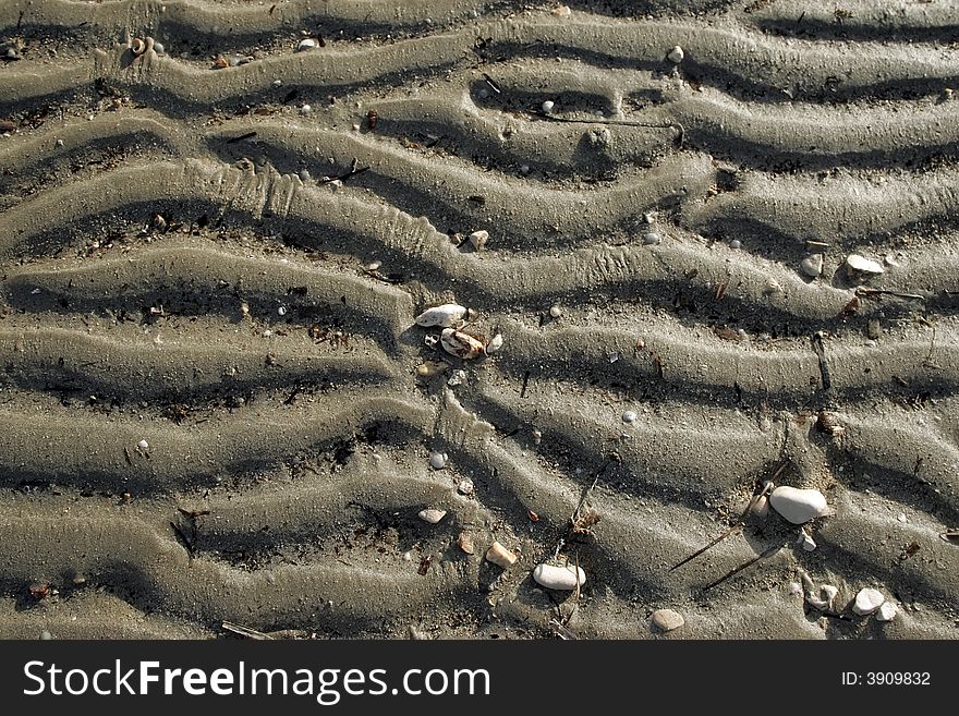 Small wave ripples in the sand at low tide . Background. Small wave ripples in the sand at low tide . Background