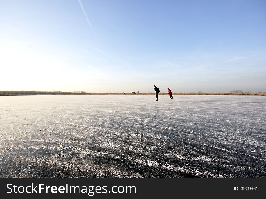 Ice skating on a wide open frozen lake in the countryside of the Netherlands. Ice skating on a wide open frozen lake in the countryside of the Netherlands