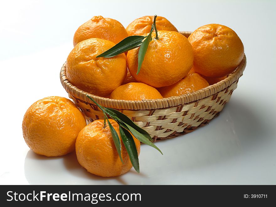 A group of fresh tangerines in a basket