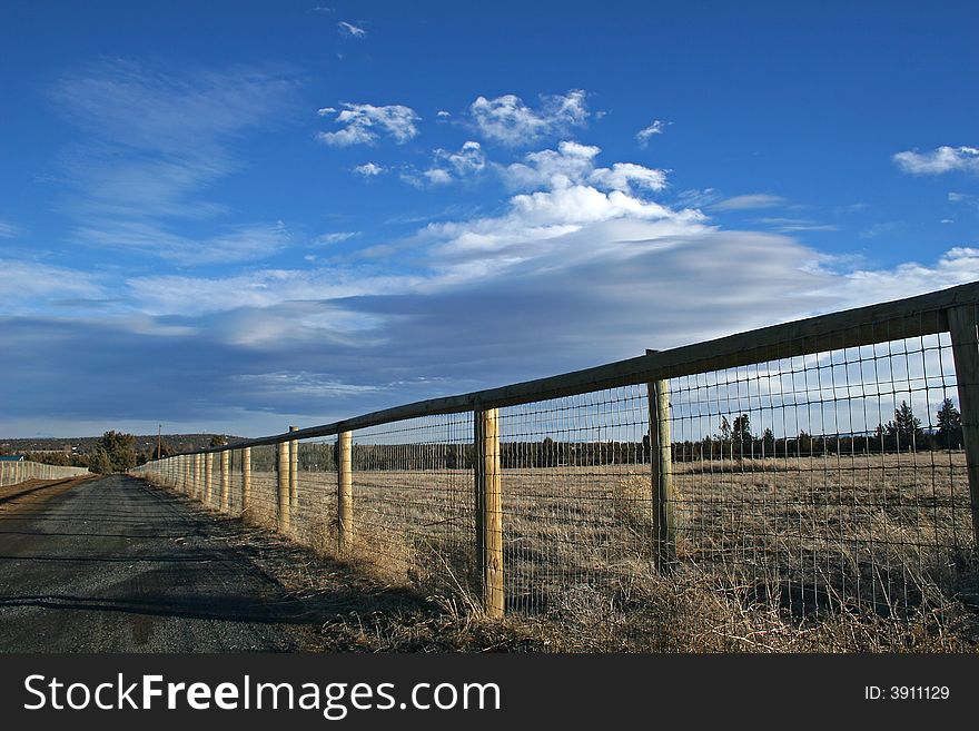 A fence and road in the country. A fence and road in the country