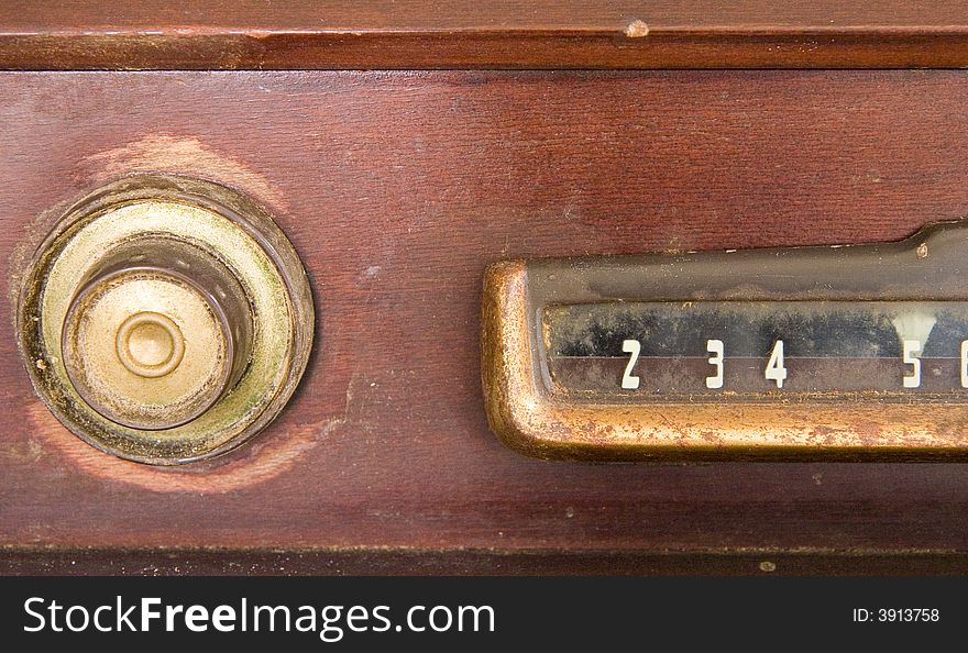 Dial and knob on an old wooden television console. Dial and knob on an old wooden television console