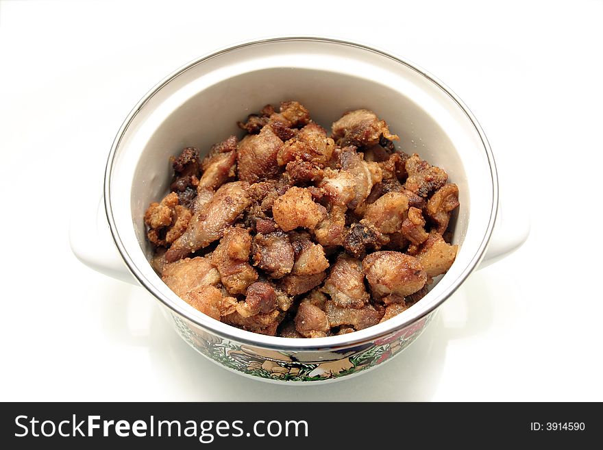Greasy chunks of meat in a pan