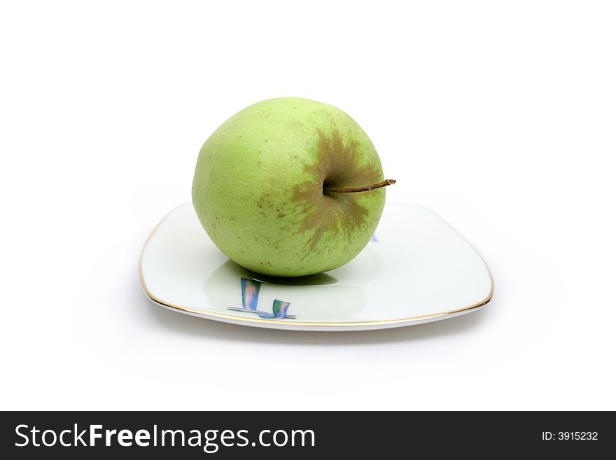 Fresh green apple on white plate on white background