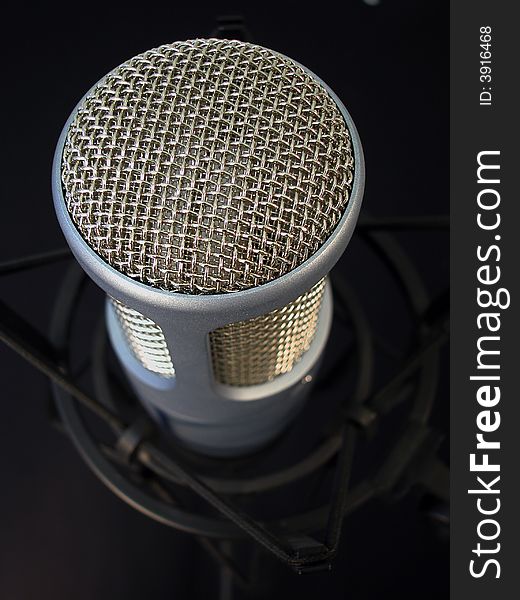 Close up shot of a professional recording studio microphone against a black background. Close up shot of a professional recording studio microphone against a black background