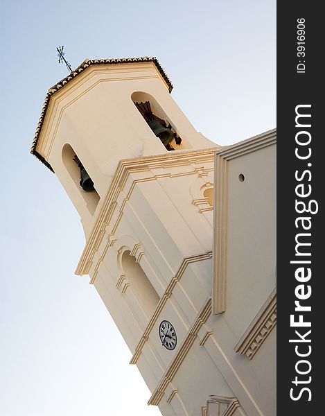Church bell tower with clock in small city Nerja near Malaga