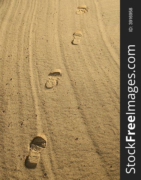 Footsteps through the sand in the evening