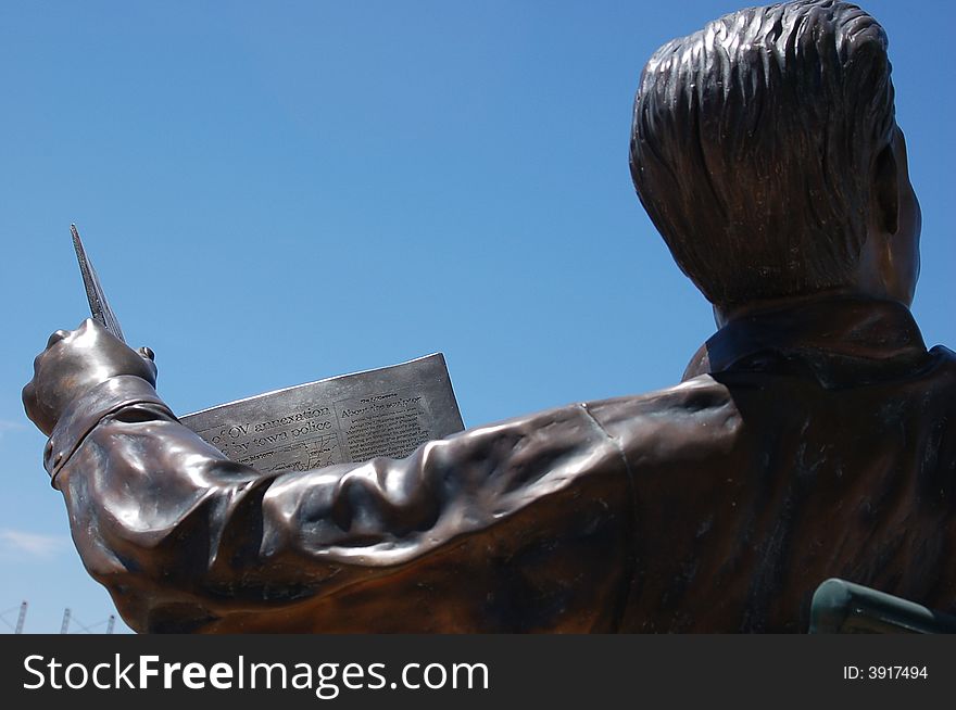 Photo of a bronze sculpture of a
man reading the newspaper. Photo of a bronze sculpture of a
man reading the newspaper.
