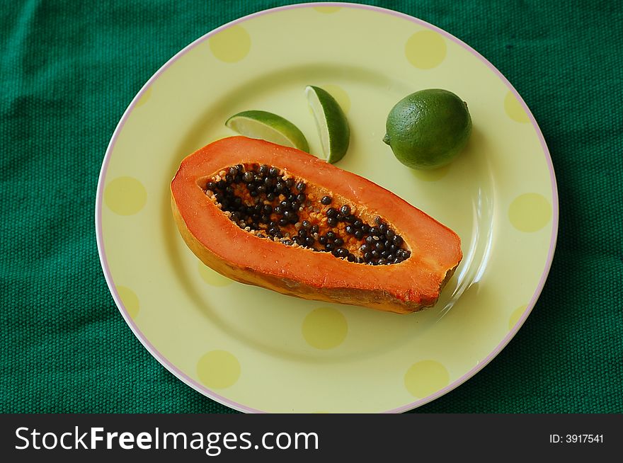 Photo of a half of papaya on a plate
with some lime on the side.