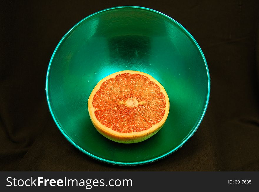 Photo of a half grapefruit in a bowl. Photo of a half grapefruit in a bowl.