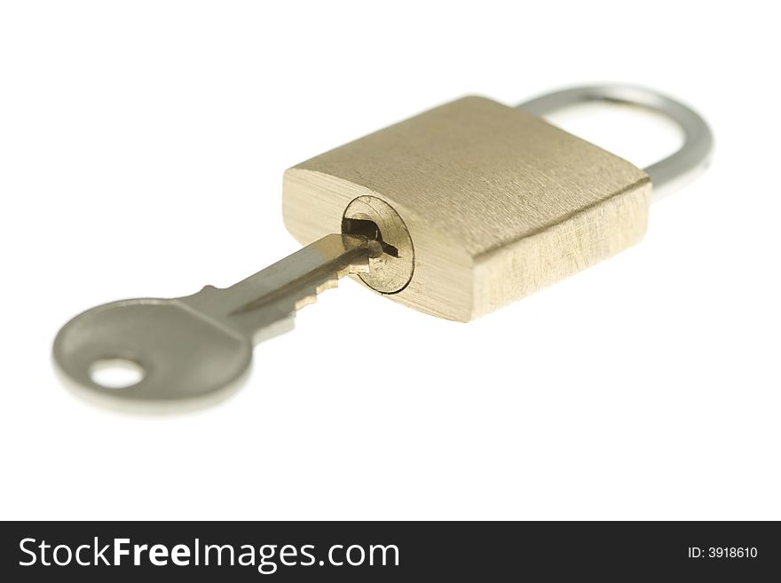 Isolated closed brass padlock with key about to op