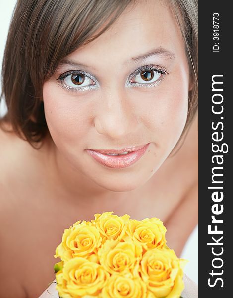 Portrait pf pretty brown-eyed girl holding yellow roses in hands. Portrait pf pretty brown-eyed girl holding yellow roses in hands