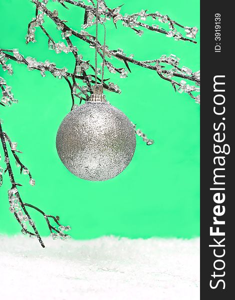 Christmas ball on green background with branch