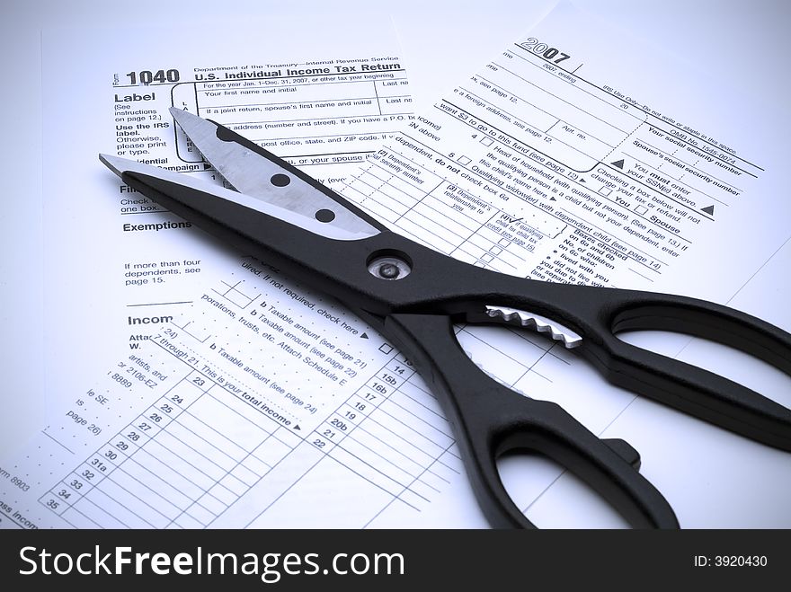 Image of scissors and a cut up tax form indicating cutting taxes.