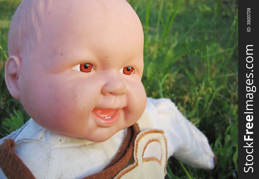 Smiling baby doll and green grass