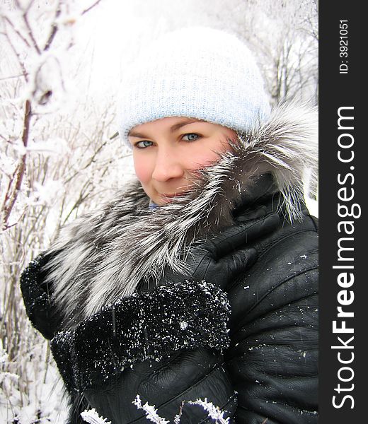Girl in winter frozen forest with fur coat