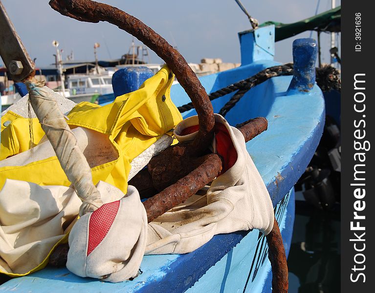 Old rusty anchor on blue boat