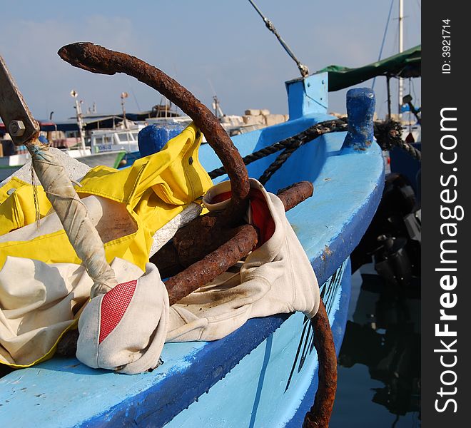 Old rusty anchor on blue boat