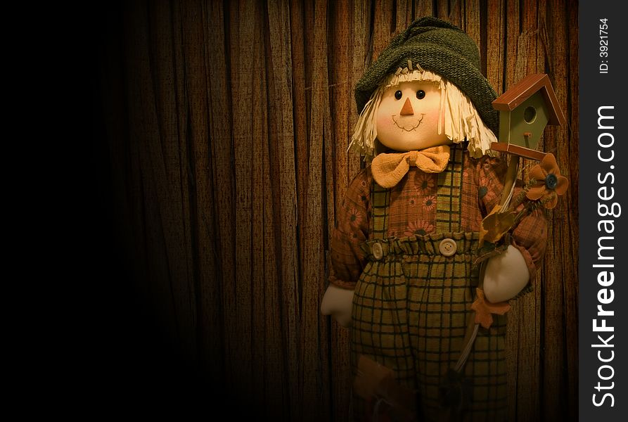Doll scarecrow in spotlight on stage in front of straw curtains. Doll scarecrow in spotlight on stage in front of straw curtains