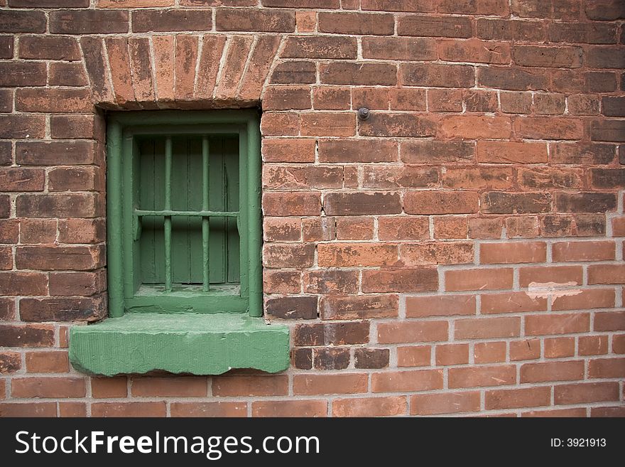 Rustic brick historic building with green window frame