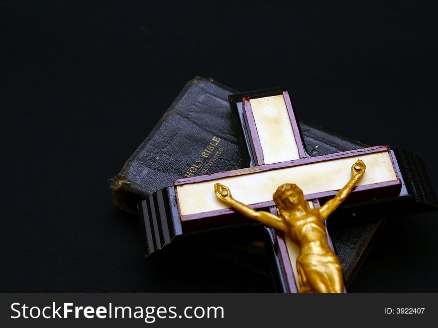 Striking full color image of an old crucifix laying on top of an ancient leatherbound bible. Striking full color image of an old crucifix laying on top of an ancient leatherbound bible