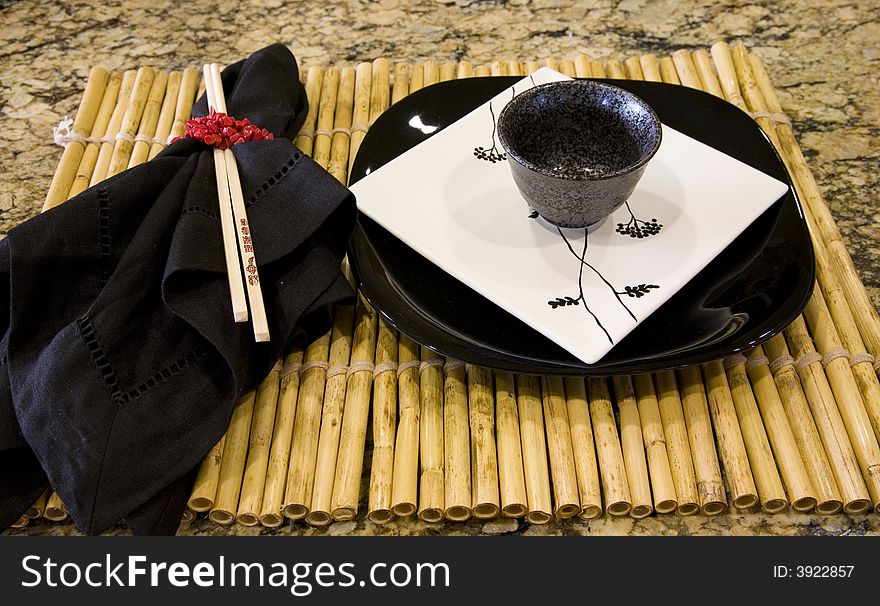 Table with modern plates, chop sticks and decor. Table with modern plates, chop sticks and decor.