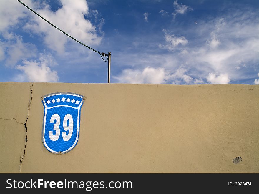 House Number 39 sign on a wall and with cloudscape
