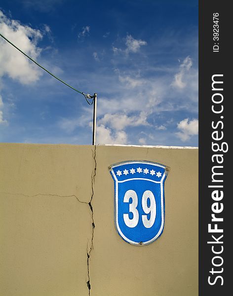 House Number 39 sign on a wall with cloudscape