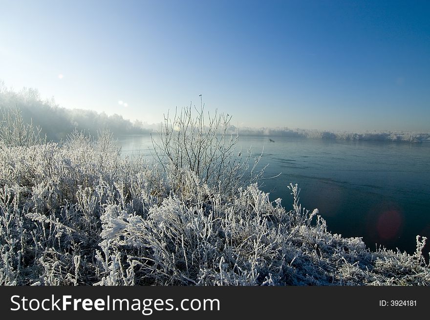 Winter wonderland lake with snow and blue sky