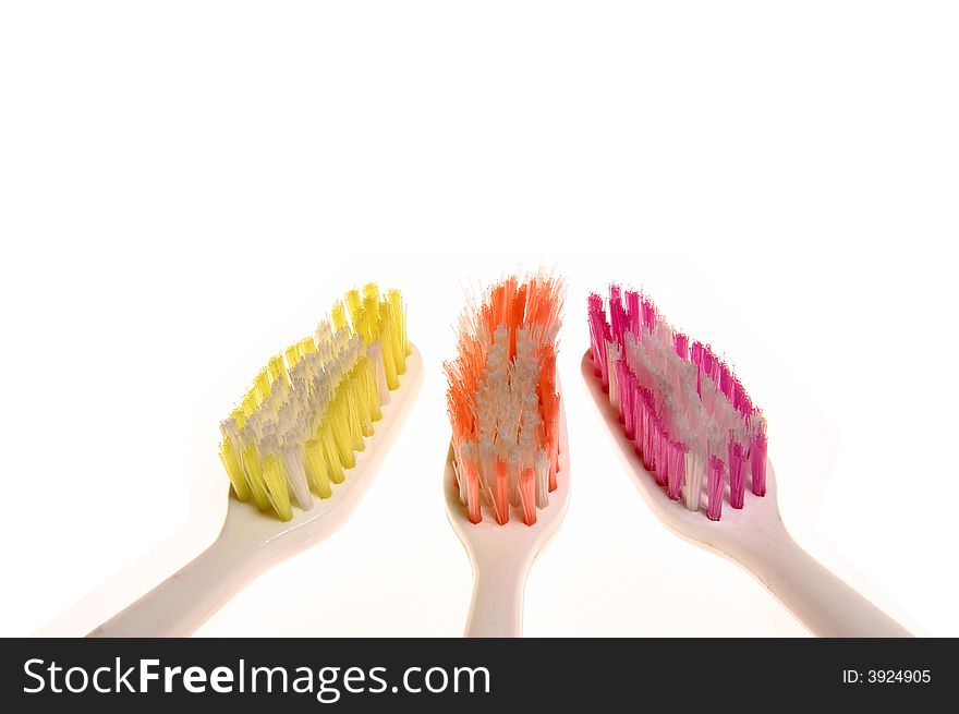 Three toothbrushes of different colors