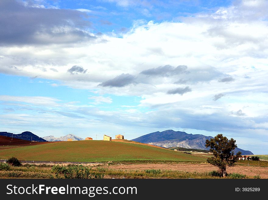 Cloudy autumnal sky and country. Beautiful autumn country landscape. cultivated land, hills, blue sky & clouds. Sicily, Italy